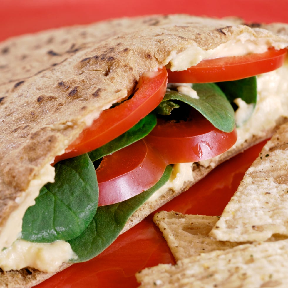 healthy vegetarian vegan pita with hummus and veggies, red plate